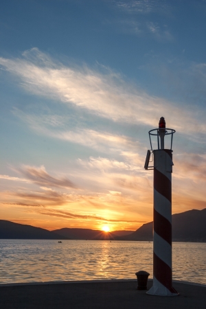 Small red lighthouse on harbor entranceの写真素材