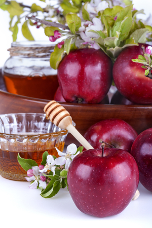 
apples in a bowl with honey and apple flower on a white backgroundの写真素材
