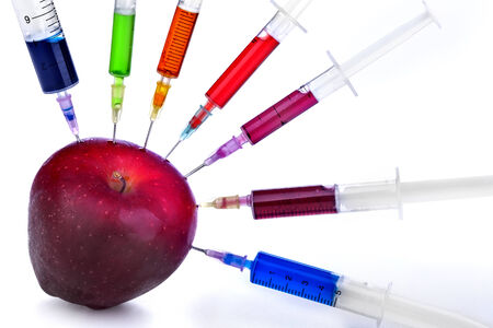 Genetic modification of fruit with a syringe full of chemicalsの写真素材