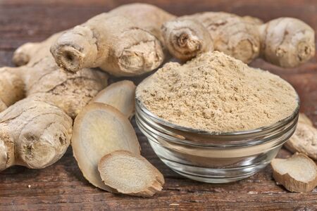 Ginger with ginger spice on wooden table