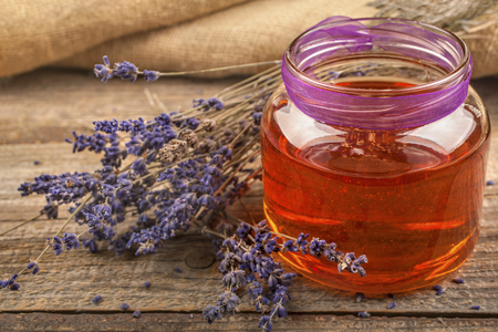 Honey from lavender with a lavender flower on a rustic backgroundの写真素材