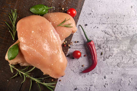 Fresh raw chicken breast, healthy chicken fillet, with seasonal vegetables and spices, cooking ingredients, on a rustic wooden background. Meat background ...の写真素材