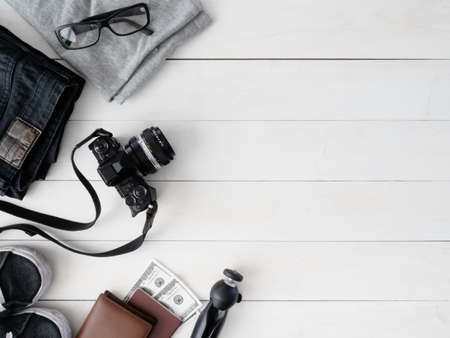 top view travel concept with digital  camera, map and Outfit of traveler on white table background, Tourist essentials, vintage tone effectの写真素材