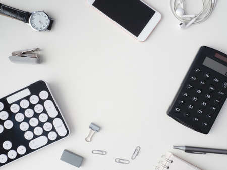 top view of office desk table with notebook, calculator, plastic plant, smartphone and keyboard on white background, graphic designer, Creative Designer concept.の写真素材