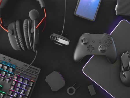 streaming games concept, top view a gaming gear, mouse, Webcams, keyboard, joystick, headset and mouse pad on black table background.の写真素材