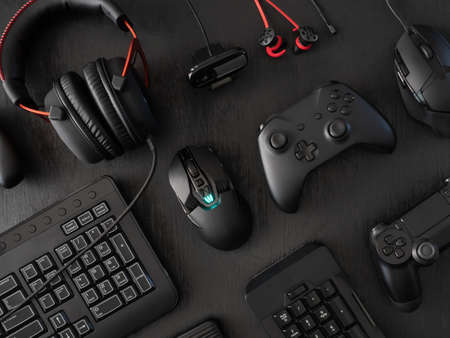 gamer work space concept, top view a gaming gear, mouse, keyboard, joystick, headset, mobile joystick, in ear headphone and mouse pad on black table background.の写真素材