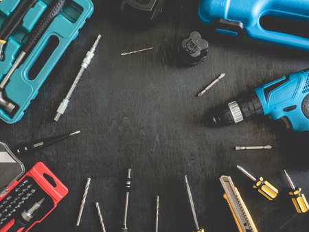 top view of Construction tools concept with Drill sets, hammer, screwdriver and Toolbox on black wooden background.の写真素材