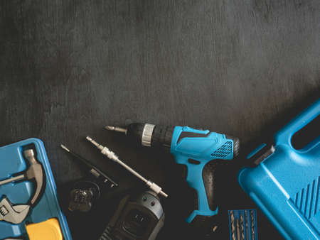 top view of Construction tools concept with Drill sets, hammer, screwdriver and Toolbox on black wooden background.の写真素材