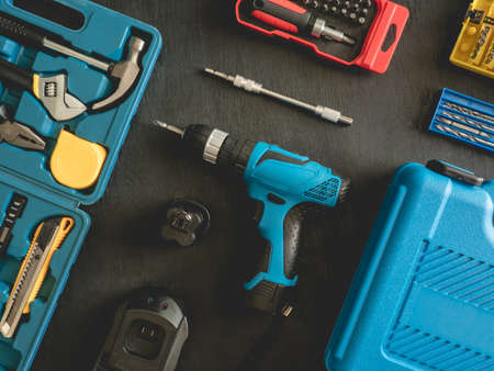 top view of Construction tools concept with Drill sets, hammer, screwdriver and Toolbox on black wooden background.の写真素材