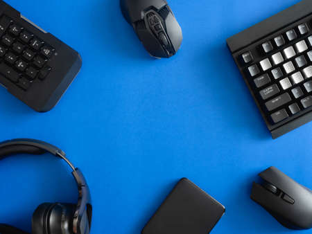 top view of computer parts with harddisk, ram, CPU, graphics card, and motherboard on blue table background.の写真素材