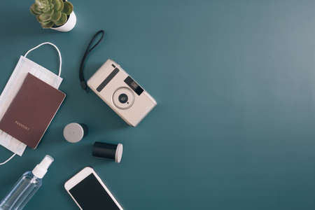 top view travel concept with camera, map, passport and disposable face mask, Tourist essentials, vintage tone effectの写真素材