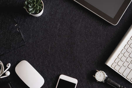 top view of office desk table with  calculator, notebook, plastic plant, smartphone and keyboard,...