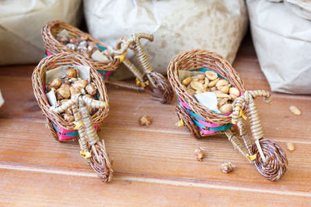 Two wicker motorcycles with nuts on a wooden table near the sack