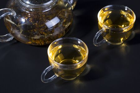 Tea pot with cups on the black backgroundの写真素材