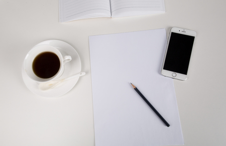 A desktop office. smart phone, coffee, notebook and pencilのeditorial素材