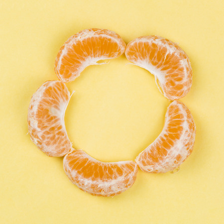 Peeled mandarin isolated on yellow background.
