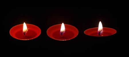 Burning candle isolated on black background.の写真素材