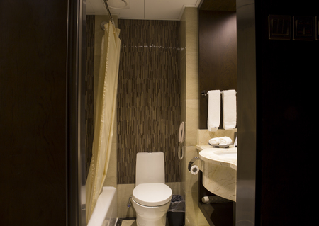 Modern bathroom layout . shower heads, large bath tub, large mirrors on walls, black marble top sink area.のeditorial素材
