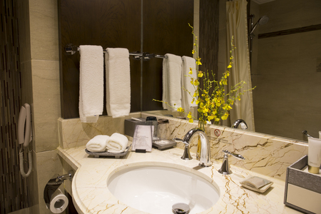 Modern bathroom layout . shower heads, large bath tub, large mirrors on walls, black marble top sink area.のeditorial素材