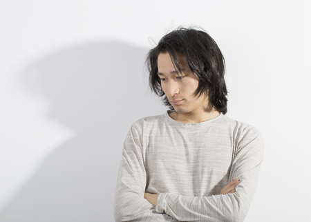 Man with long hair isolated on white background in a stressed motion. Man with anxiety.の写真素材