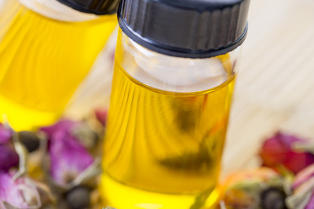 Essential oils with rose  buds on the tableの写真素材