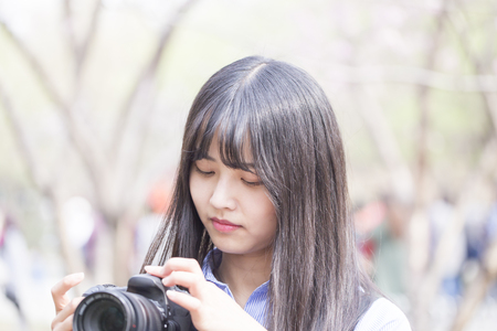 Pretty girl with DSLR camera in spring timeの写真素材