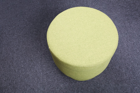 Top view of yellow stool sitting on gray floor.