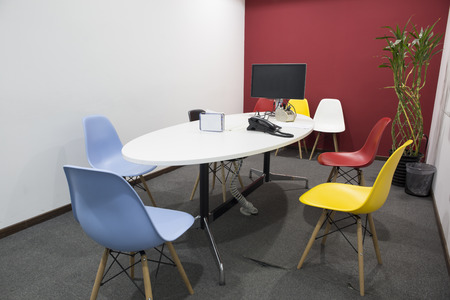 Office empty meeting room with liquid crystal display and telephone. Colorful chairs and board.のeditorial素材