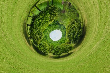 Green grass with flowers and trees in spring. Shape of the planet.の写真素材