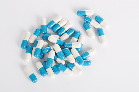 Closeup of medical blue pills on the white background.