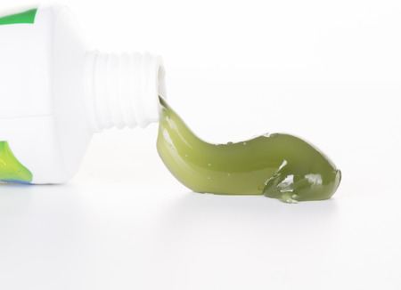 Fresh green gel toothpaste oozing out of tube. Closeup.の写真素材