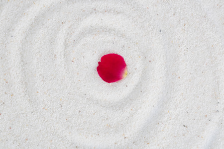 Spa image spiritual balance and healthy lifestyle, rose flower petals on the white sand.の写真素材