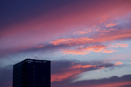 Beautiful sunset sky and high building silhouette.