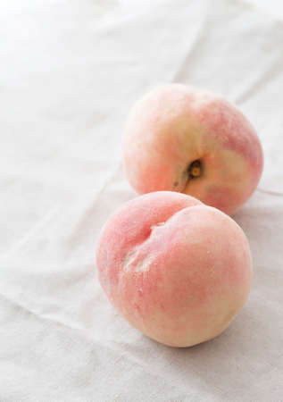 Two fresh peaches on the table.の写真素材