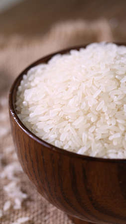 Close up of white rice in the wooden bowl.