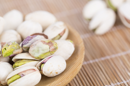 Closeup view Of Pistachio Nuts on bamboo matの写真素材
