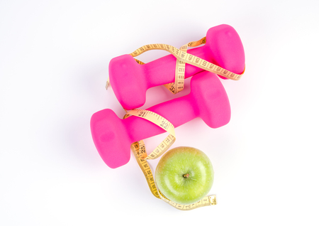 Dumbbells, fresh green apple and measure tape isolated on white backgroundの写真素材