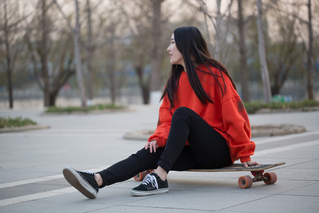 Young woman sitting on her skateboardの写真素材