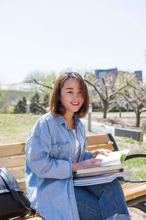 Young woman reading on bench