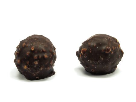 sweet chocolate balls filled with hazelnuts and flips on a white background. 
の写真素材