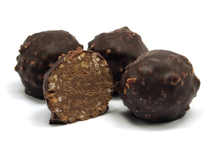 sweet chocolate balls filled with hazelnuts and flips on a white background. 
の写真素材