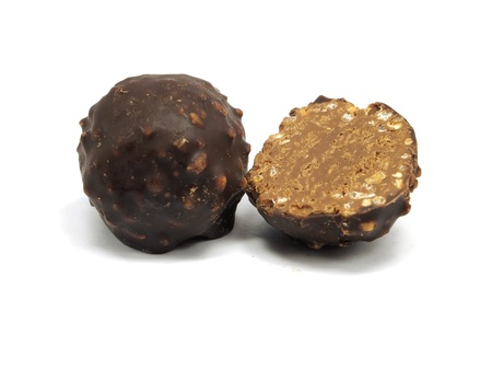 sweet chocolate balls filled with hazelnuts and flips on a white background. 
の写真素材