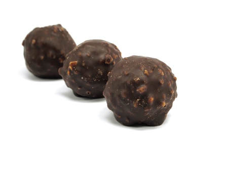 sweet chocolate balls filled with hazelnuts and flips on a white background. 
の写真素材