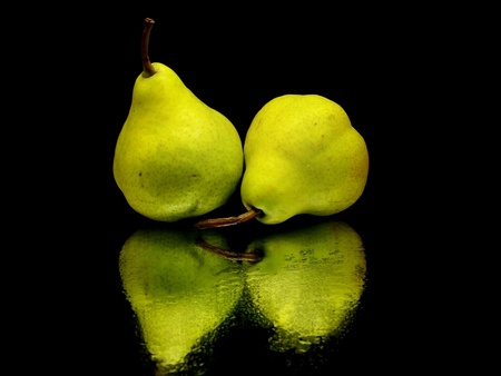 green pear on a black background with water dropsの写真素材