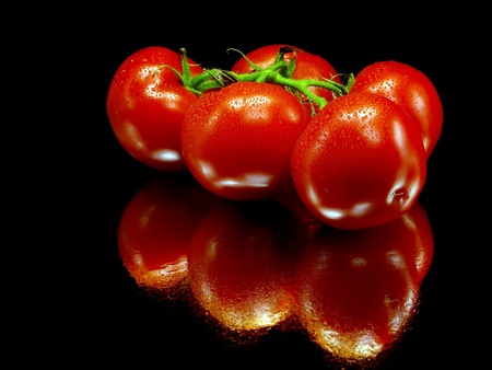 fresh tomatoes on a black background with water drops     の写真素材