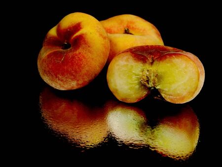 Exotic flat peach on a black background with water drop
の写真素材