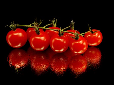 bunch of fresh cherry tomato on a black background with water drops 
  の写真素材