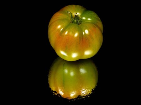 fresh unripe tomatoes on a black background with water drops 
の写真素材