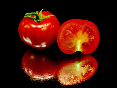 fresh tomatoes on a black background with water drops     の写真素材