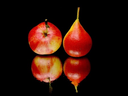 organic red pear and apple on a black background with water drops 
    の写真素材